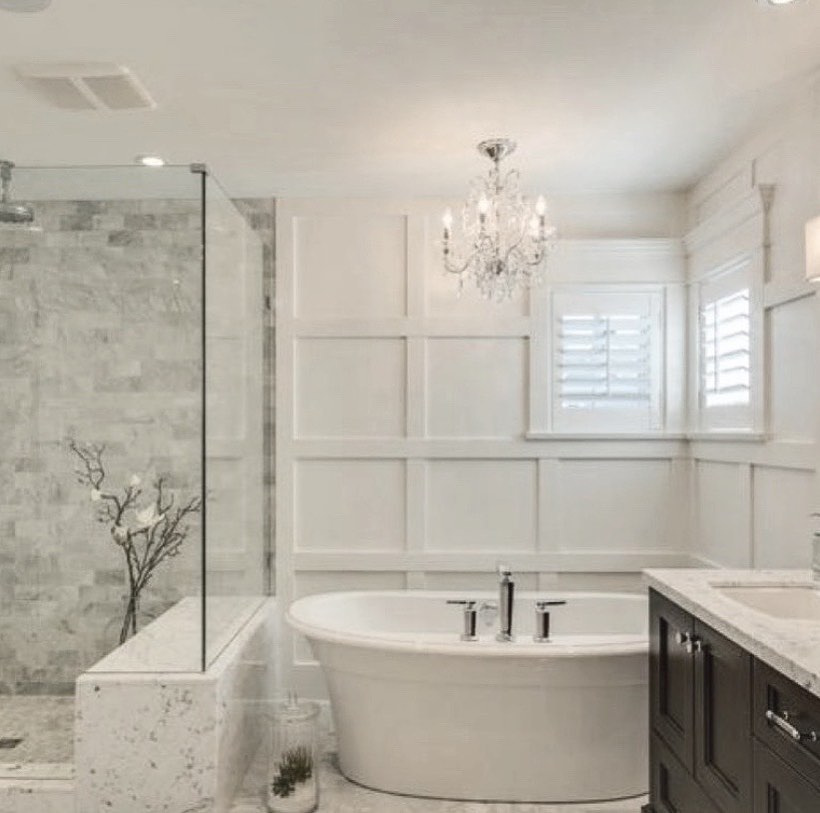 master bathroom with glass shower, soaking tub and natural tiles