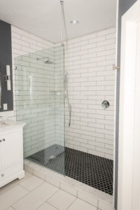 Glass shower door white subway tile