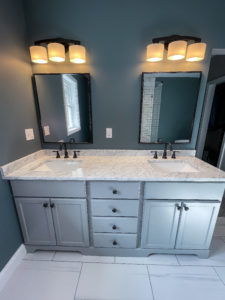 Grey bathroom vanity with white marble countertop and porcelain tiles